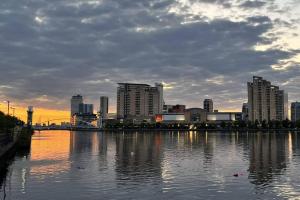 een skyline van de stad met een lichaam van water met gebouwen bij Old Trafford: Self-Serviced One Bedroom Apartment in Manchester