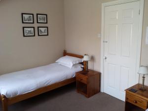 1 dormitorio con 1 cama, 2 lámparas y puerta en Glenade en Bath