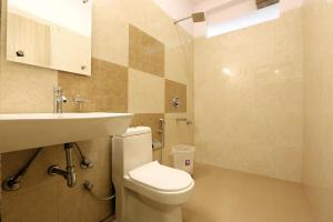 a bathroom with a white toilet and a sink at Plazzo Prime Plaza in New Delhi