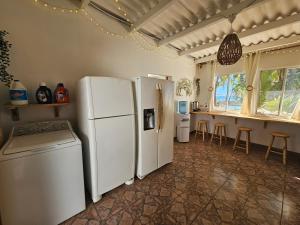 ラ・リベルタードにあるSunset Surf Villaのキッチン(白い冷蔵庫2台、カウンター付)