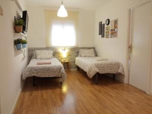a room with two beds and a table and a window at bcn4days Apartments in Hospitalet de Llobregat