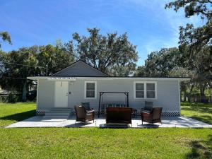 a small white house with chairs in front of it at Home in Kissimmee with Huge Backyard in Kissimmee