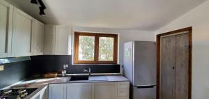 Una cocina con refrigerador de acero inoxidable y ventana. en Casa Vacanze Sakè, en Àrbatax