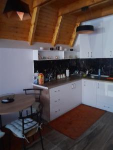 a kitchen with white cabinets and a wooden table at Villa Tina in Štrpce