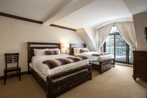 a bedroom with two beds and a large window at Tremblant Prestige - Bondurant 95-15 in Mont-Tremblant +16 photos