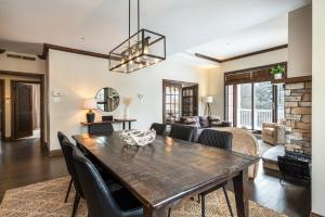 uma sala de jantar e sala de estar com mesa e cadeiras em BONDURANT 95-15 / Luxury 3 bdr on the village em Mont-Tremblant