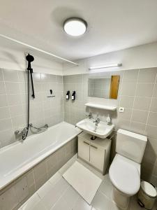 uma casa de banho com um WC, uma banheira e um lavatório. em Stilvolles Wohnen am Hafen em Bregenz