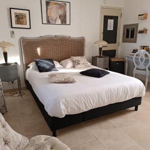 una camera da letto con un letto grande con lenzuola e cuscini bianchi di Chambre d'hôtes du Mas de Longuefeuille a Malaucène Altre 64 foto