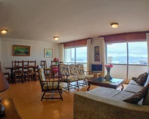 sala de estar con sofá, sillas y mesa en Apartamento con excelente localización y vistas al mar, en Sanxenxo