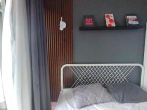 a bed with a white headboard in a bedroom at Studio Healing at Sayana Apartemen Harapan Indah Bekasi 