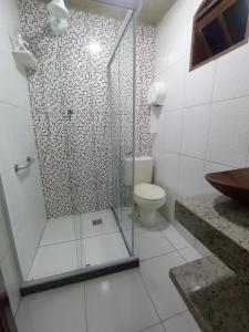 ein Bad mit einer Dusche, einem WC und einem Waschbecken in der Unterkunft Loft IMTur in Praia Sêca