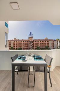 - une table à manger avec des chaises et une vue sur un bâtiment dans l'établissement Chic & Stylish near Yumbo, à Playa del Ingles