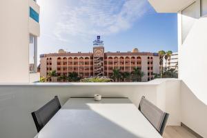 une table et des chaises sur un balcon avec vue sur un immeuble dans l'établissement Chic & Stylish near Yumbo, à Playa del Ingles