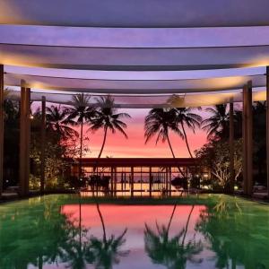 a view of a resort with a pool and a sunset at Minh Phu Quoc lodge beach swimming pool in Phu Quoc