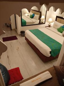 a bedroom with two beds and a mirror at Hostel Nirvana in Udaipur