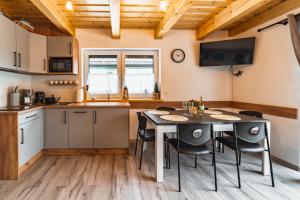 a kitchen and dining room with a table and chairs at Domki Wichrowe Wzgórze in Wisła