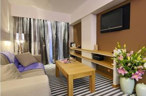 a living room filled with furniture and a tv at Galaxy City Center Hotel in Patra
