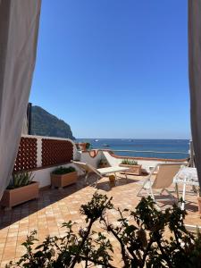a patio with chairs and a view of the ocean at The Lodge by the sea in Ischia