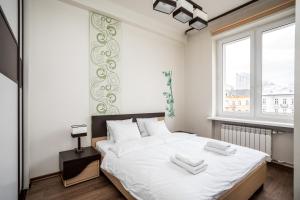 una camera da letto con un grande letto con lenzuola bianche di Apartamenty Wawa Centrum by Your Freedom a Varsavia