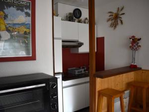 a small kitchen with a stove and a microwave at Studio Font-Romeu-Odeillo-Via, 1 pièce, 4 personnes - FR-1-580-58 in Font-Romeu-Odeillo-Via