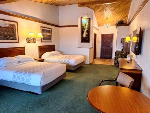 ein Hotelzimmer mit 2 Betten und einem Tisch in der Unterkunft The Devlin in Lake Placid