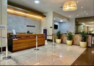 eine Lobby mit einer Rezeption und Topfpflanzen in der Unterkunft Flat Brookfield Towers in Goiânia