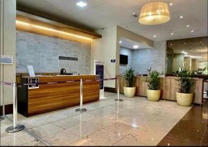 a lobby with a reception desk and potted plants at Flat Brookfield Towers in Goiânia