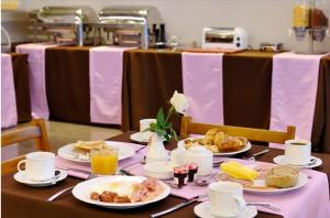 a table with plates of food on top of it at Galaxy City Center Hotel in Patra