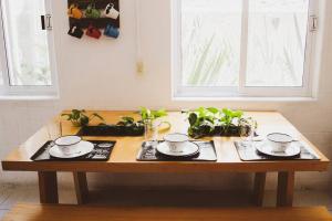 una mesa de madera con dos platos, vasos y plantas en Casa Balam Condesa, en Ciudad de México 47 fotos más