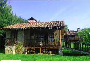 a small house with a balcony in the grass at La Tierra Grande in Zacatlán