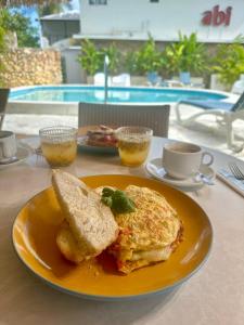 un plato amarillo con un desayuno de huevos y tostadas en El Rincon de Abi, en Las Terrenas