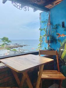 a wooden picnic table with a view of the ocean at CasAMARelo Hostel in Salvador