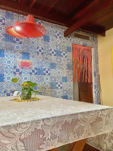 Habitación con mesa y azulejos azules y blancos. en CasAMARelo Hostel en Salvador