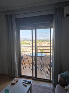 sala de estar con una puerta corredera de cristal que da a un balcón en Carpediem in Spanje, en San Miguel de Salinas