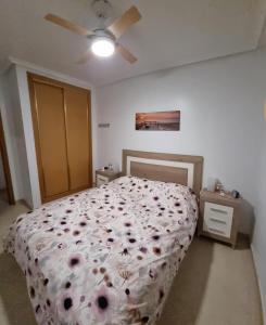 Un dormitorio con una cama con flores. en Carpediem in Spanje, en San Miguel de Salinas