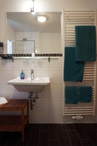y baño con lavabo y toallas verdes. en Hotel - Ristorante La Grotta, en Speyer