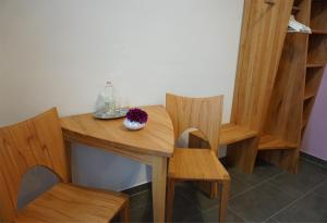 Hotel - Ristorante La Grotta في شباير: طاولة وكراسي خشبية عليها إناء ورد