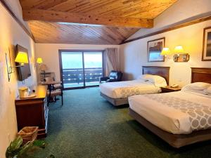 a hotel room with two beds and a balcony at The Devlin in Lake Placid