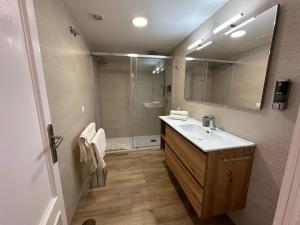 een badkamer met een wastafel en een douche met een spiegel bij Luceros 310 New in Alicante