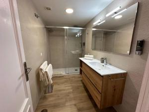 a bathroom with a sink and a shower with a mirror at Luceros 310 New in Alicante +13 photos