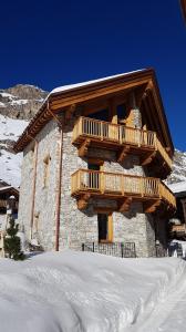 a log cabin with a balcony in the snow at Chalet Chez Sylvain in Le Fornet