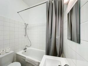 een badkamer met een bad, een toilet en een wastafel bij Cosy Appartement, Vaise Salengro 2 in Lyon