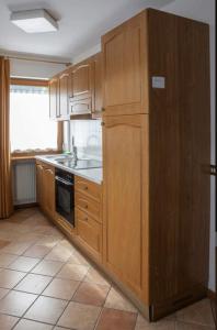 una cucina con armadi in legno e frigorifero di Residence Malibu Appartamento 6 a Falcade