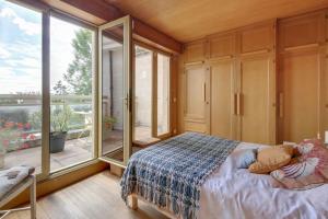 a bedroom with a bed and a large window at Villa des Oliviers in Fontenay-sous-Bois