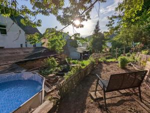 un giardino con sedia e piscina di Urlaubsmagie - Helle Wohnung mit Garten & Pool - R3 a Rathmannsdorf