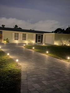 a house with lights on the side of a driveway at Cozy House in SE Cape Coral. Pet-friendly! in Cape Coral