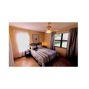 um quarto com uma cama e uma ventoinha de tecto em Cozy House in SE Cape Coral. Pet-friendly! em Cape Coral