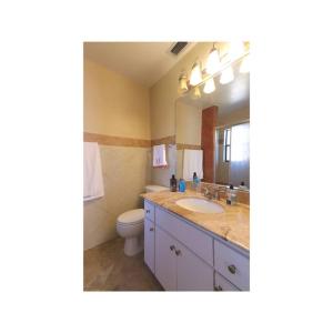 a bathroom with a sink and a toilet and a mirror at Cozy House in SE Cape Coral. Pet-friendly! in Cape Coral