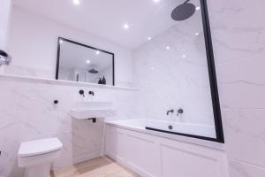a white bathroom with a sink and a mirror at The Wagon Shed Stylish Conversion with Garden and Parking in Sowerby Bridge +71 photos
