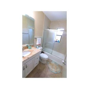 uma casa de banho com um lavatório, um WC e um espelho. em Cozy House in SE Cape Coral. Pet-friendly! em Cape Coral